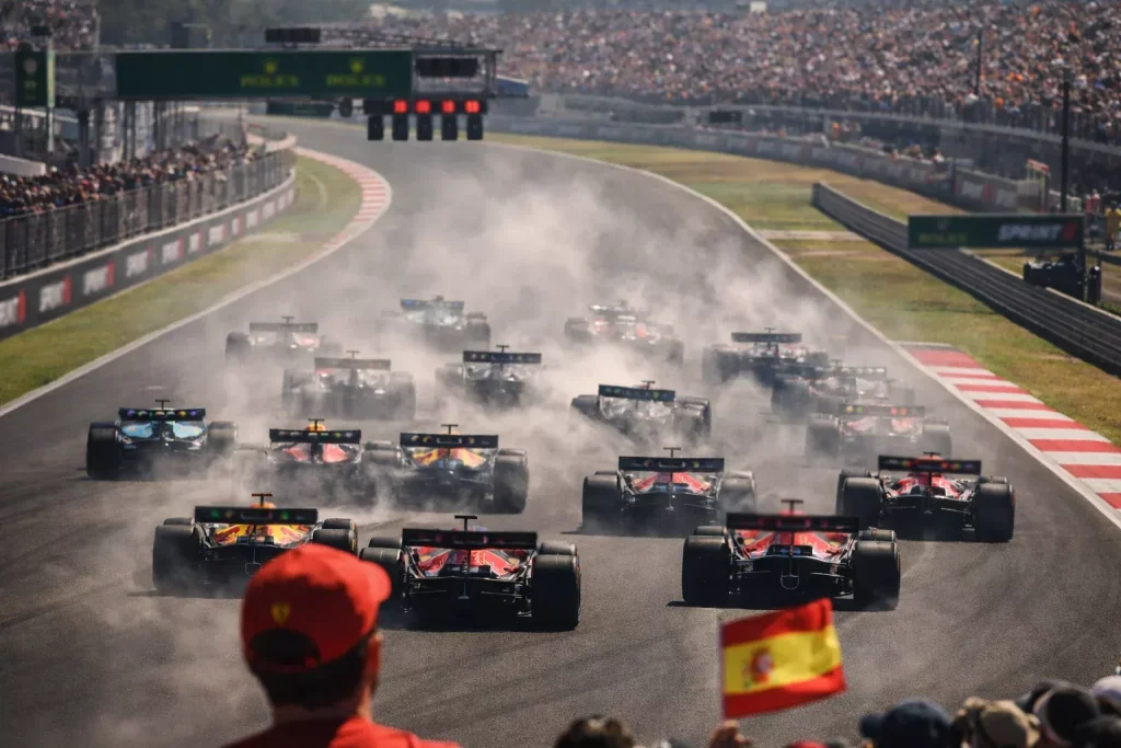 Salida de una carrera sprint de F1 con monoplazas agrupados en la primera curva