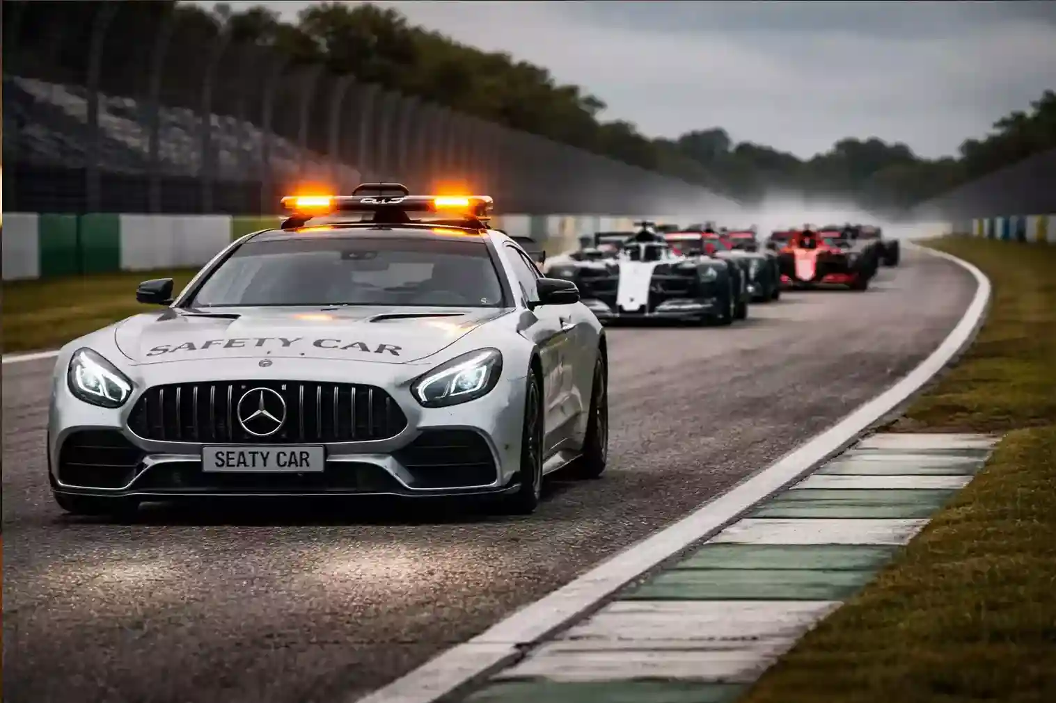 Safety Car de F&oacute;rmula 1 liderando el pelot&oacute;n de monoplazas en circuito