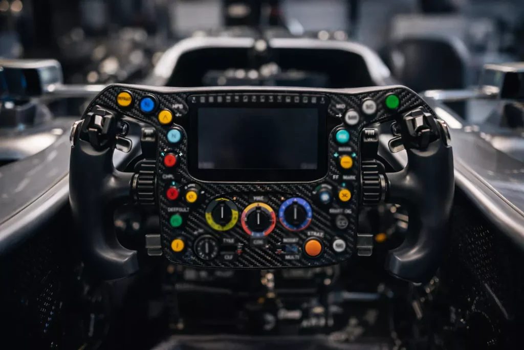 Primer plano de un volante de F1 con botones y pantalla de datos